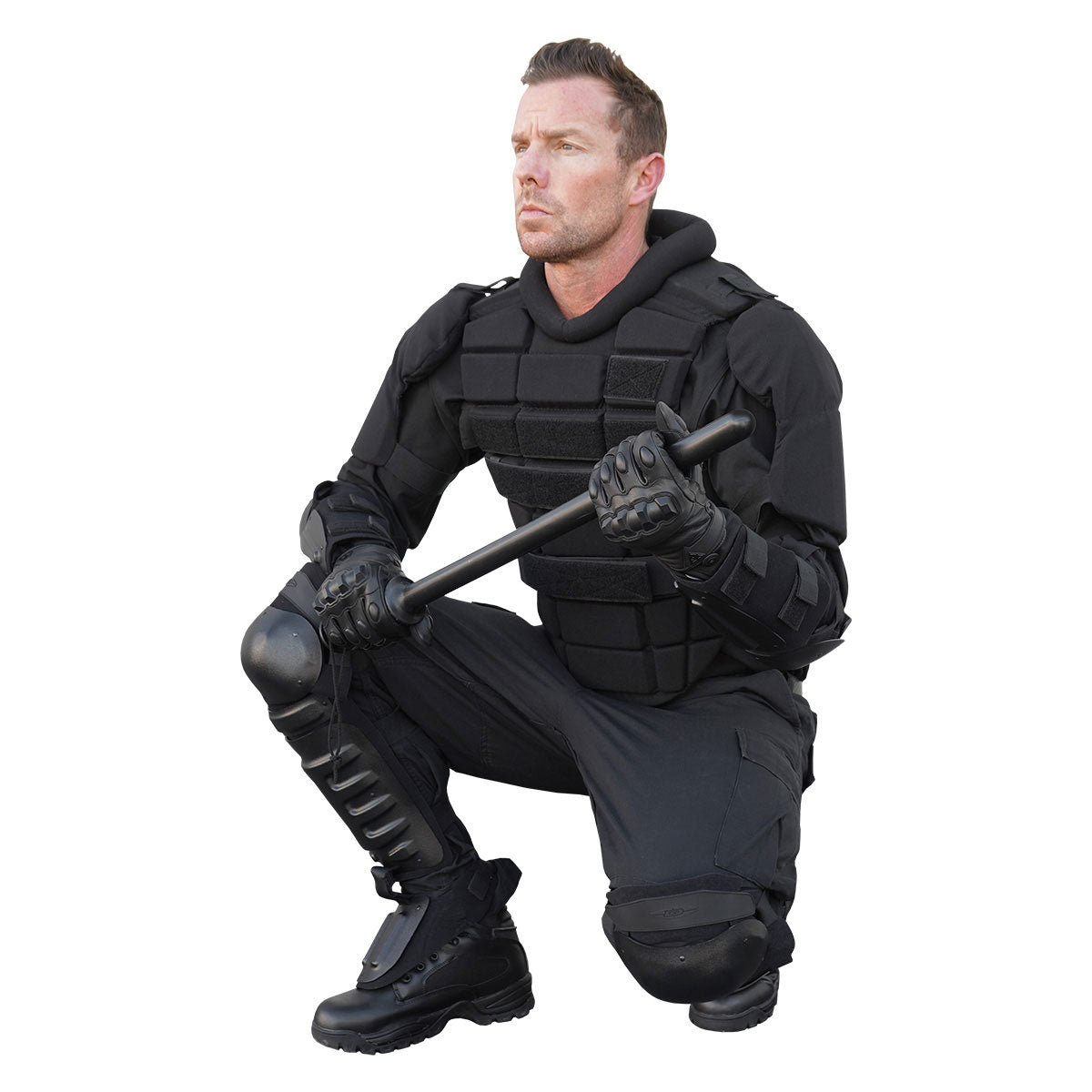 Male officer in tactical gear kneeling with a baton, showcasing readiness for riot control with protective gloves.