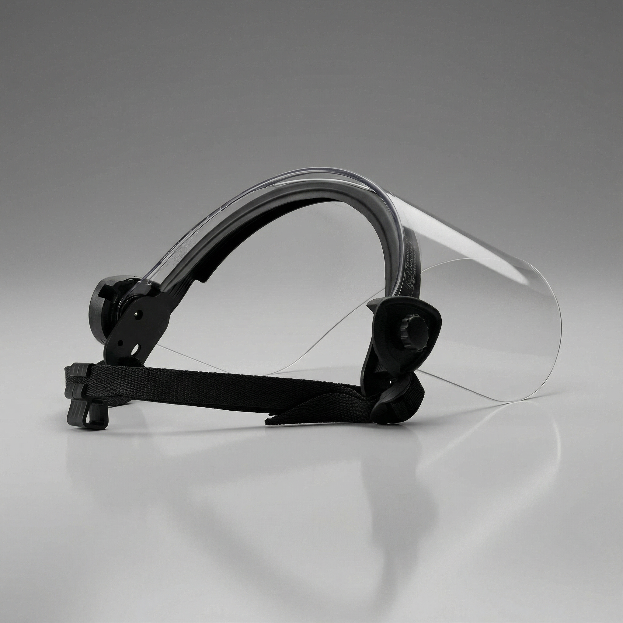 Clear face shield with black headband on a gray background