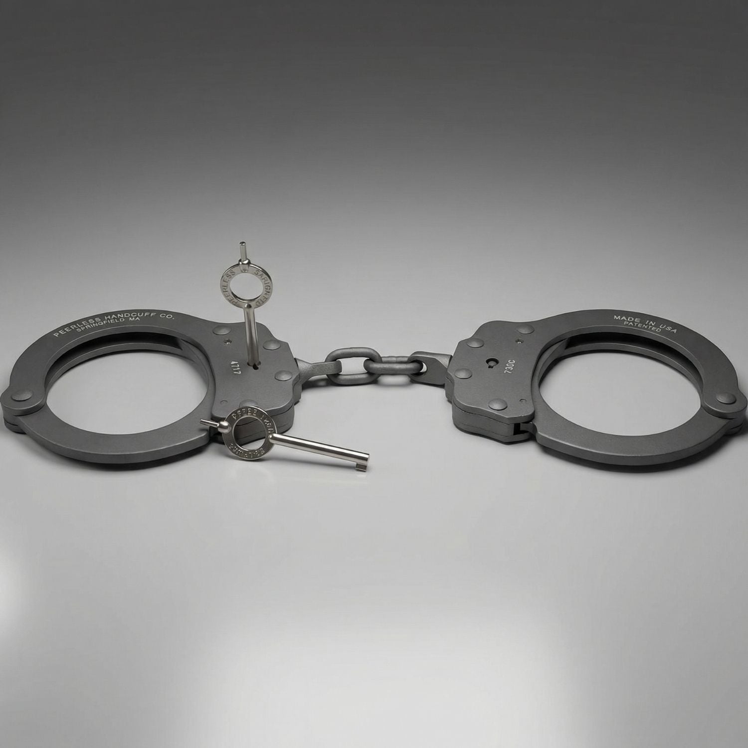 Pair of handcuffs on a reflective gray surface