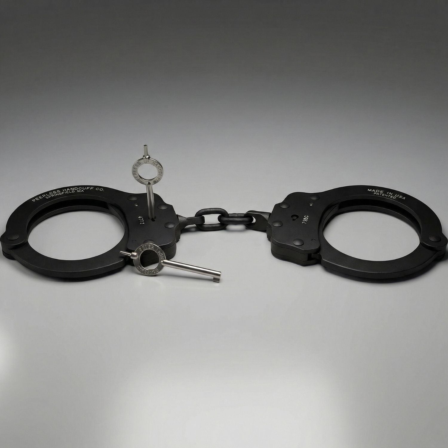 Black handcuffs with a key on a gray background