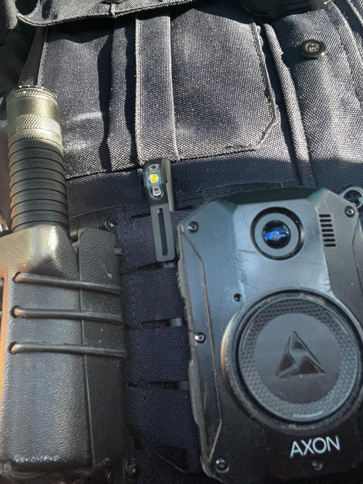 Police officer wearing a QuiqLite LiteStick Hands-Free LED Pocket Light for First Responders
