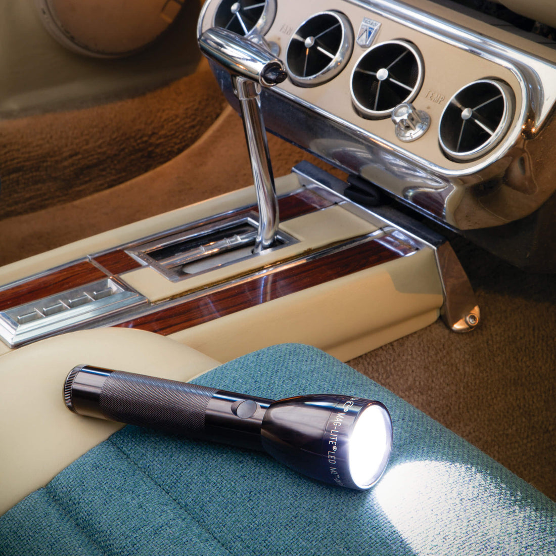 Maglite ML50L 2 C-Cell LED Flashlight model ML50L in assorted colors. Flashlight on a car seat with chrome dashboard in the background