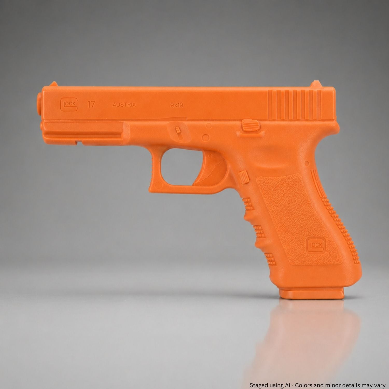 Orange training gun on a reflective surface with a gray background