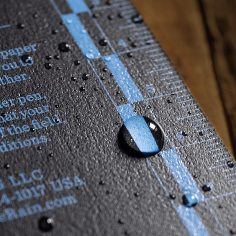 Close-up of a water droplet on a textured surface with text and blue lines.