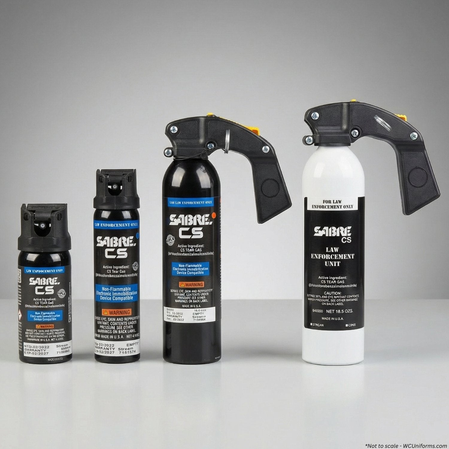 Collection of Sabre CS pepper spray canisters on a gray background