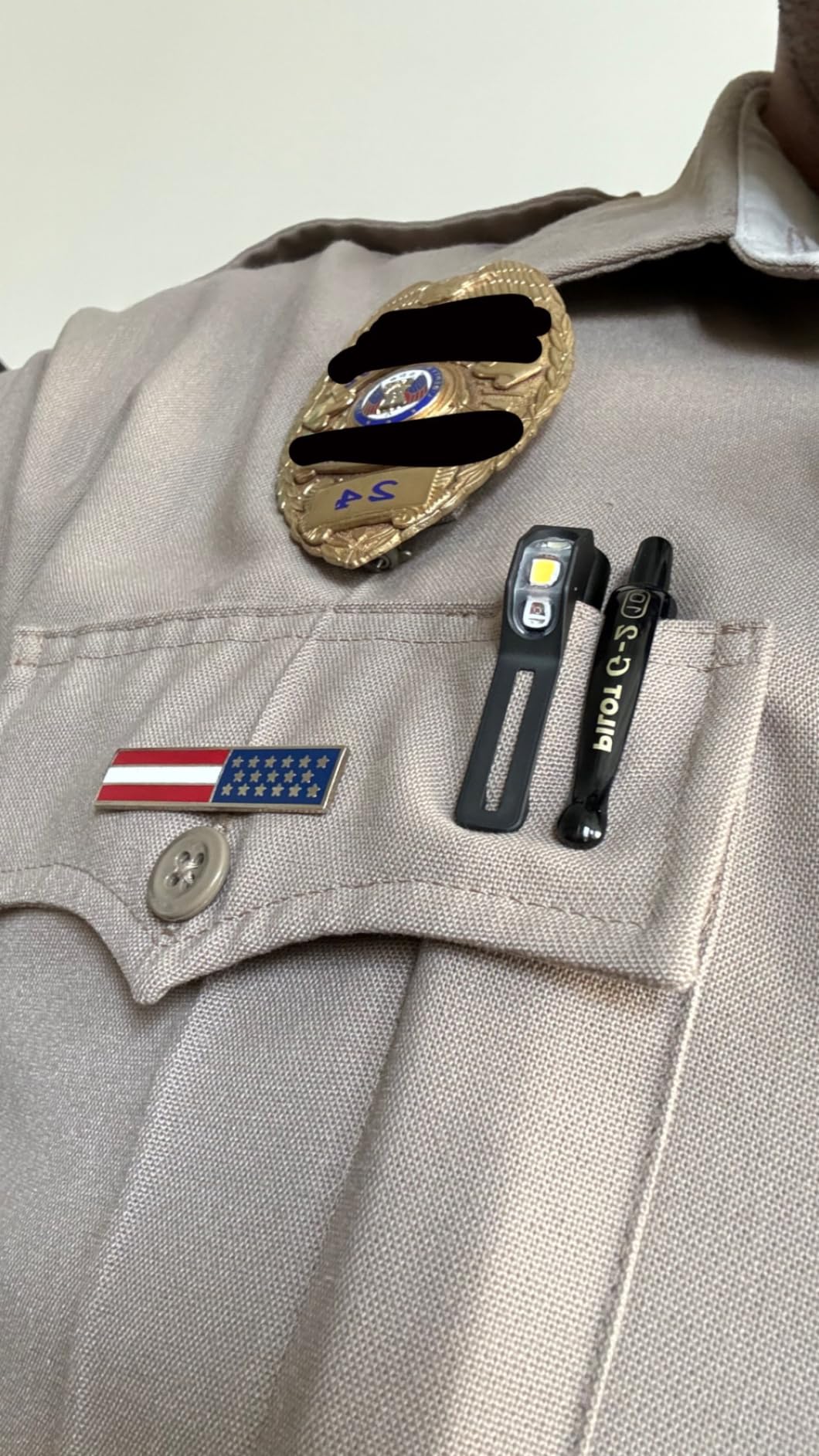 Security guard wearing Video a QuiqLite LiteStick Hands-Free LED Pocket Light for First Responders