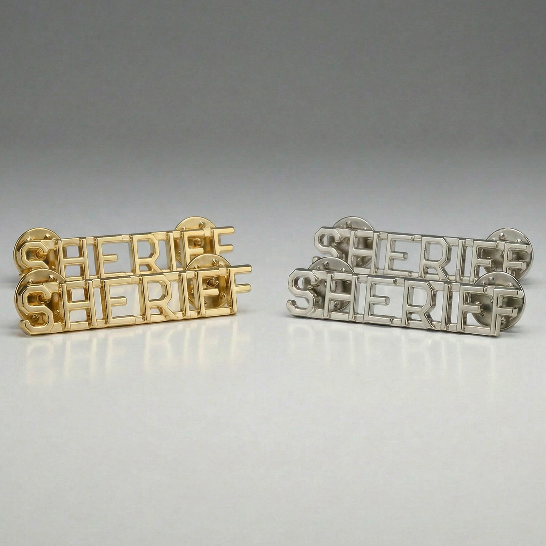 Gold and silver 'SHERIFF' badges on a gray background