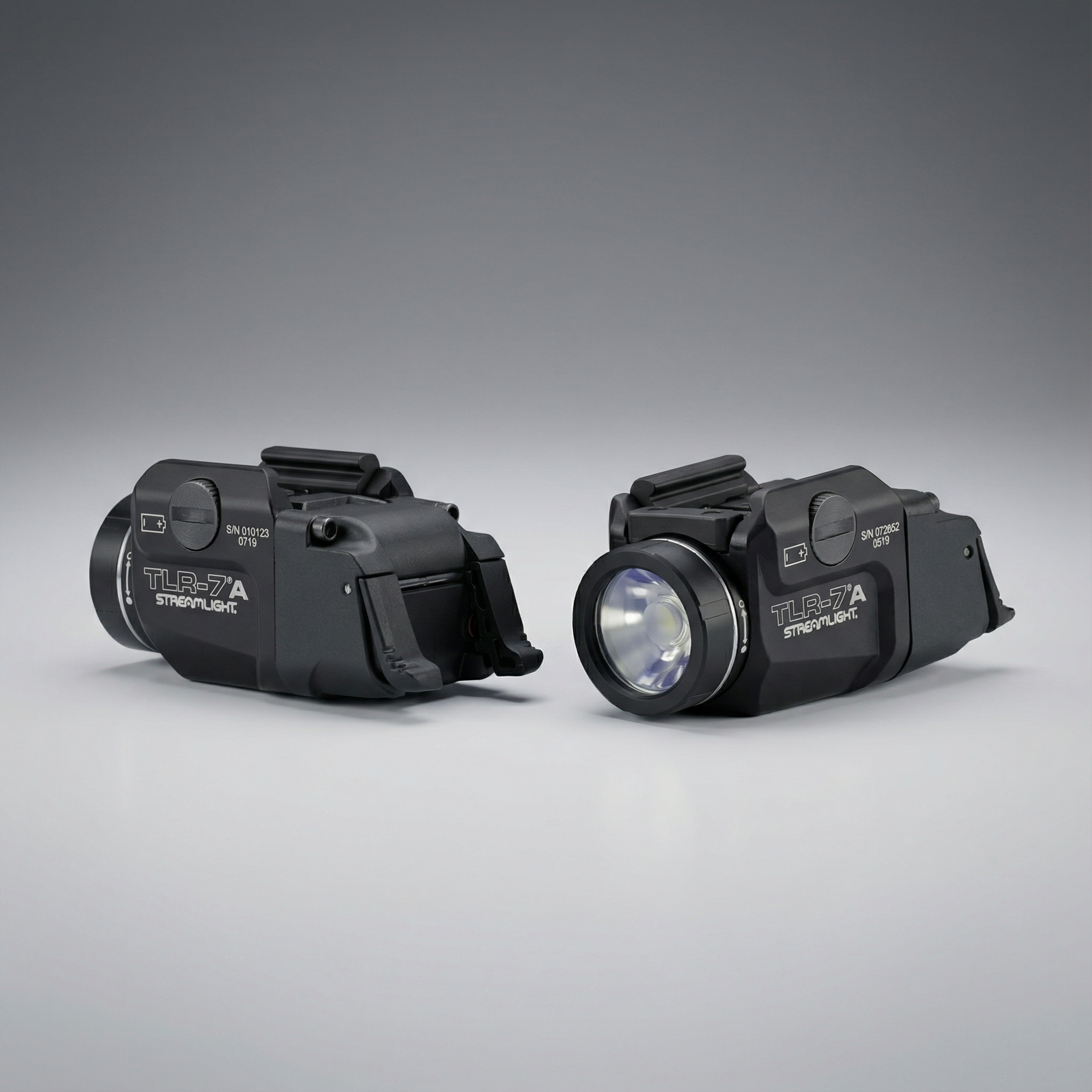 Two black tactical lights on a gray background