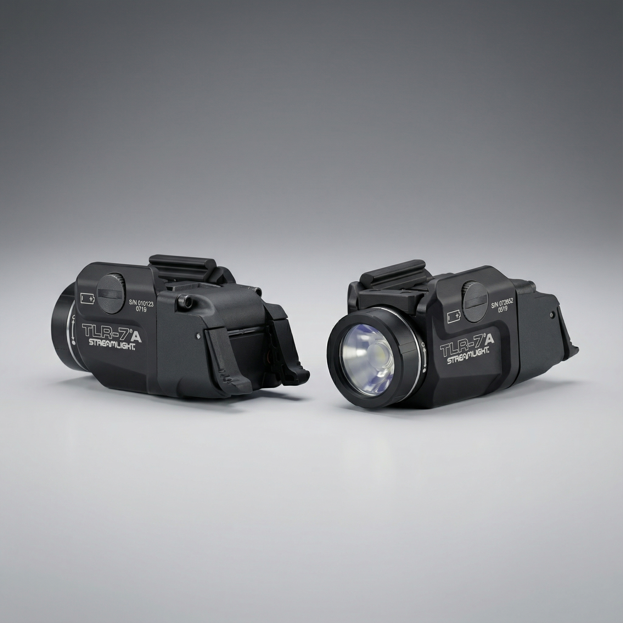 Two black tactical lights on a gray background