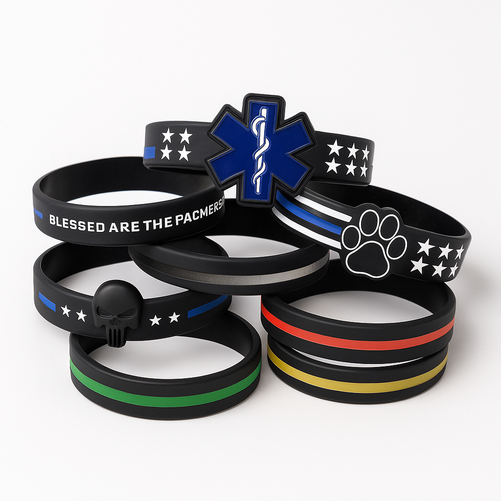 Collection of black rubber bracelets with various symbols and text on a white background