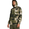 Person wearing a camouflage hoodie with a brand logo on a white background