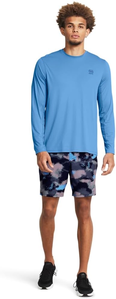 Man wearing a blue long-sleeve shirt and tie-dye shorts on a white background