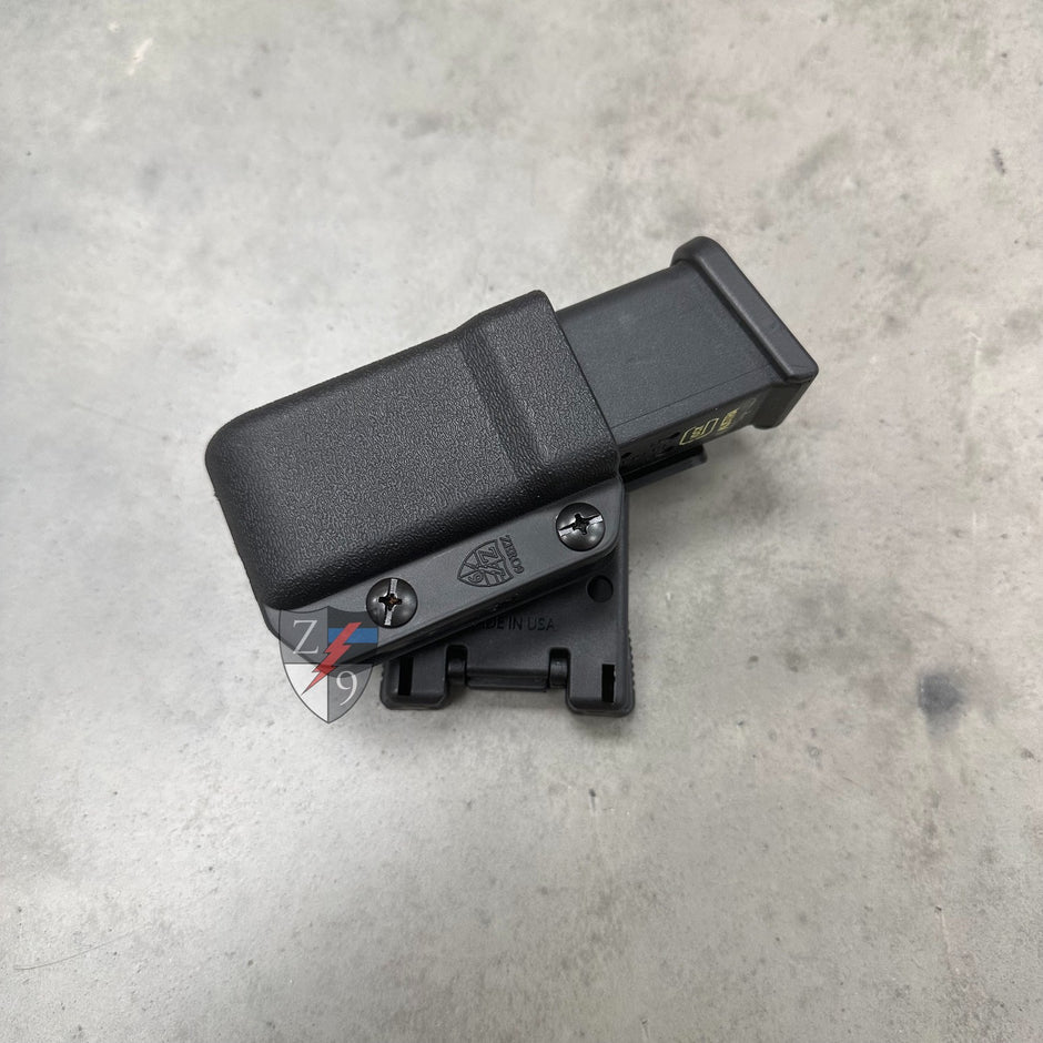 Black gun magazine on a gray concrete surface