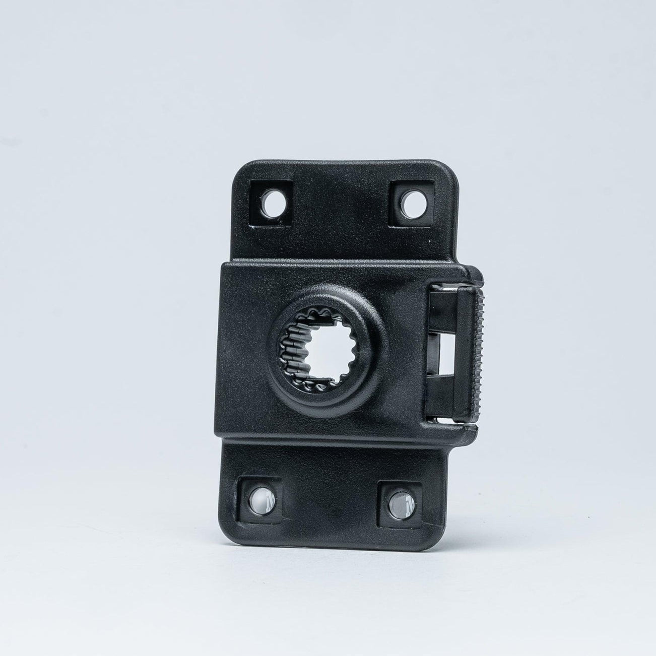 A small black plastic mounting bracket or hardware component with a circular slot and four screw holes, photographed on a clean light gray studio background.