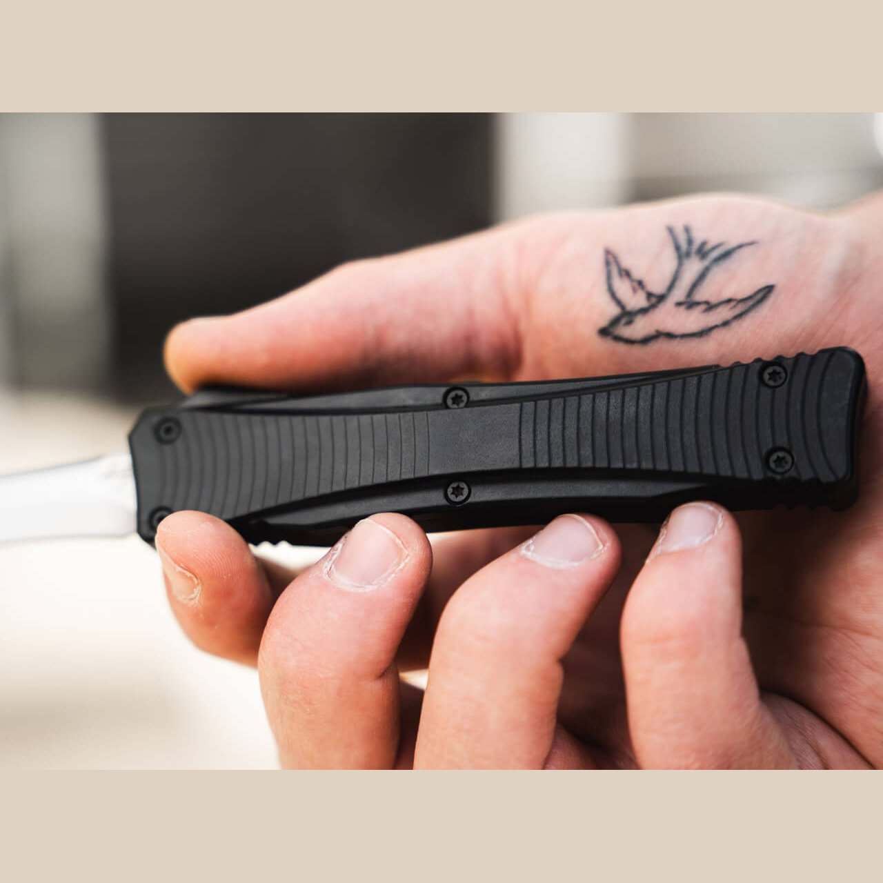 Grooved black aluminum handle of the Böker Plus Eagle 2.0 OTF knife held in hand