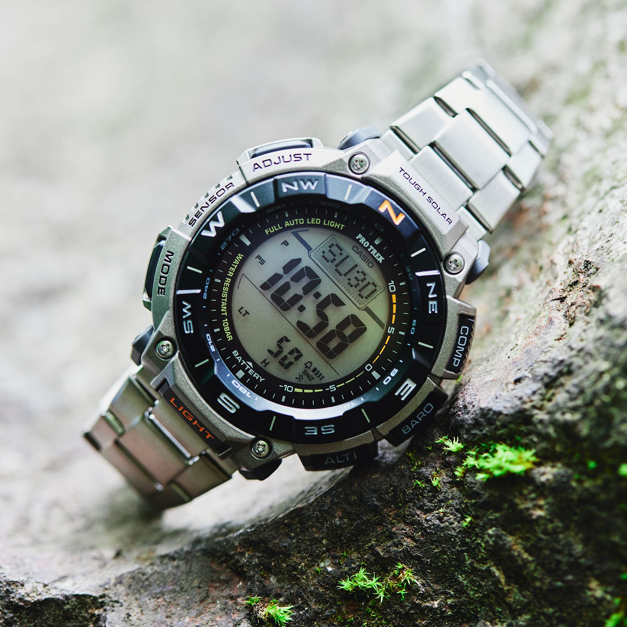 Digital wristwatch with metal band on a textured surface