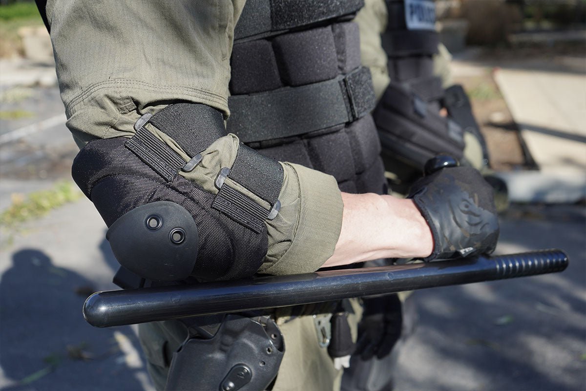 Police officer in riot gear holding the Damascus DRB24T PR-24 side handle baton in use