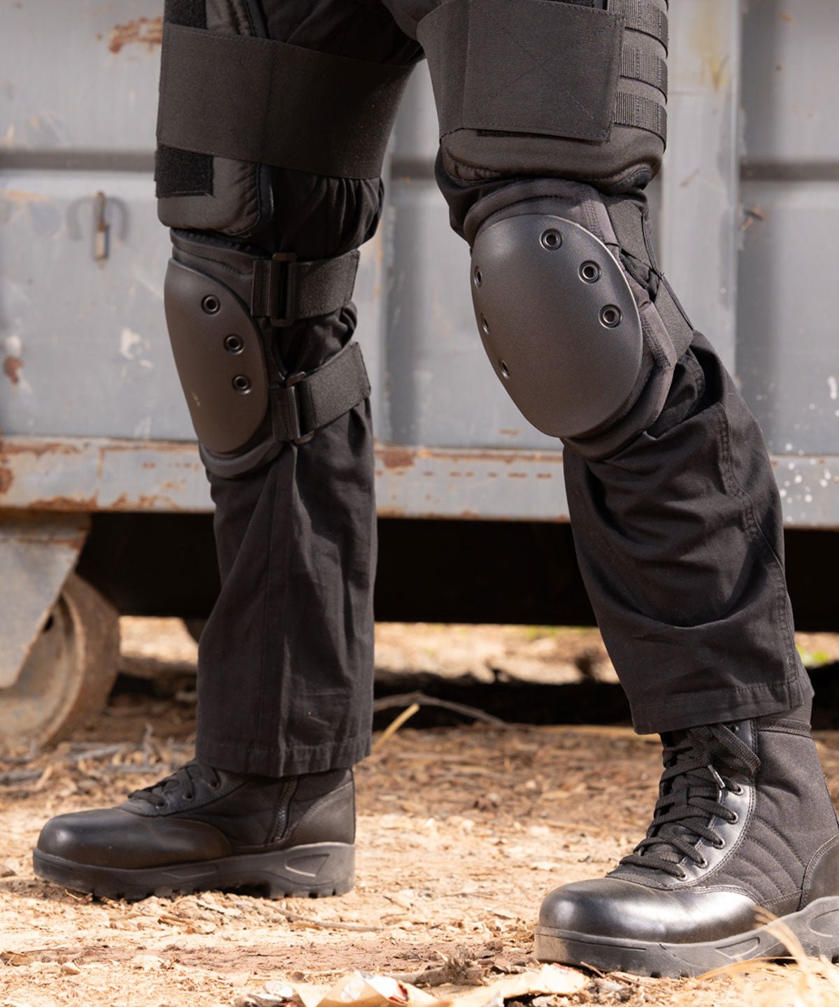 Officer wearing black Damascus Imperial DKP hard shell cap knee pads over tactical pants and boots