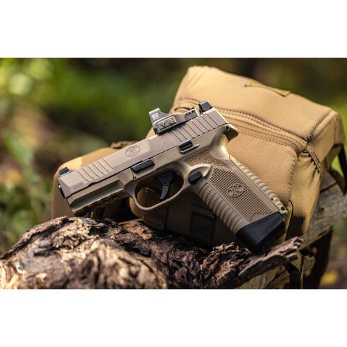 EOTech EFLX Mini Red Dot Sight mounted on a tan pistol resting on a log near a backpack.