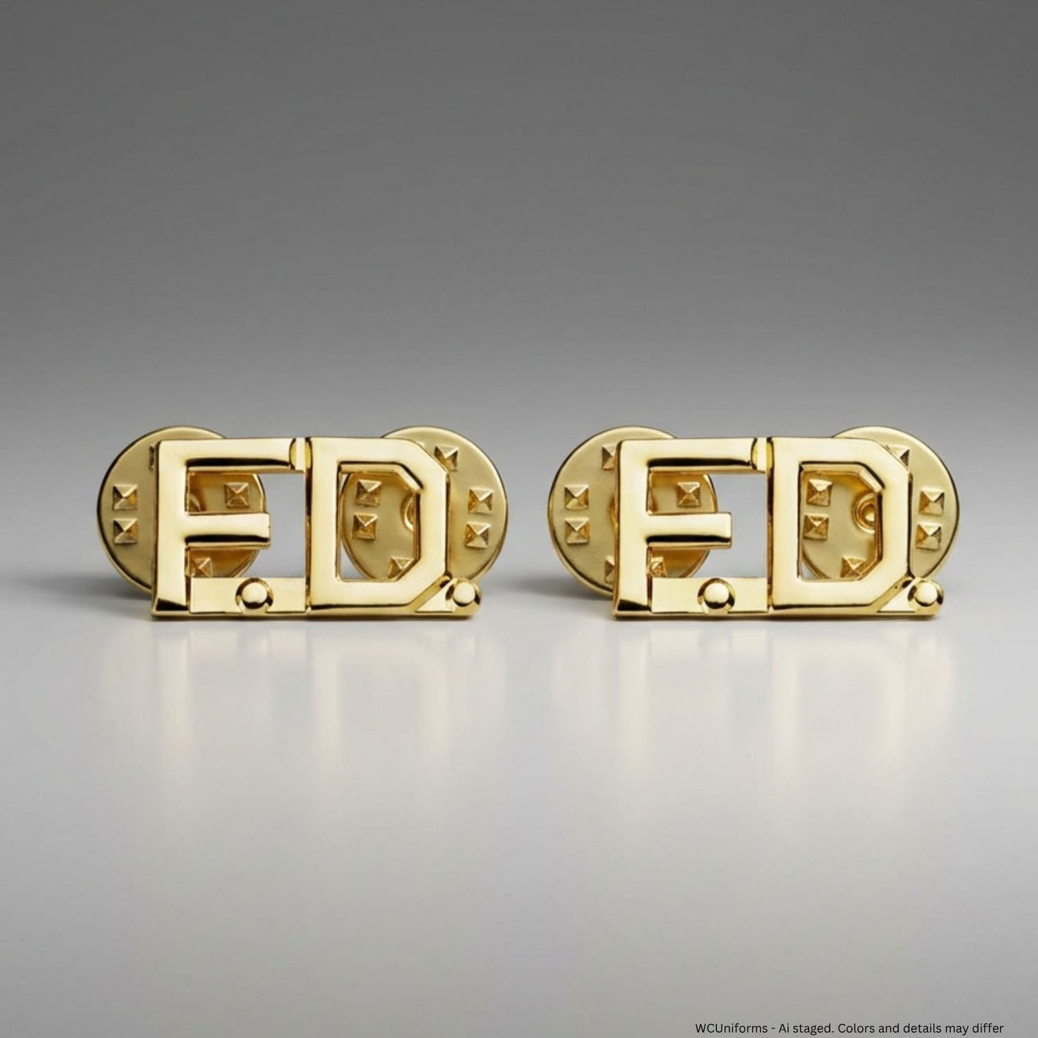 Gold collar pins with 'F.D.' design on a gray background