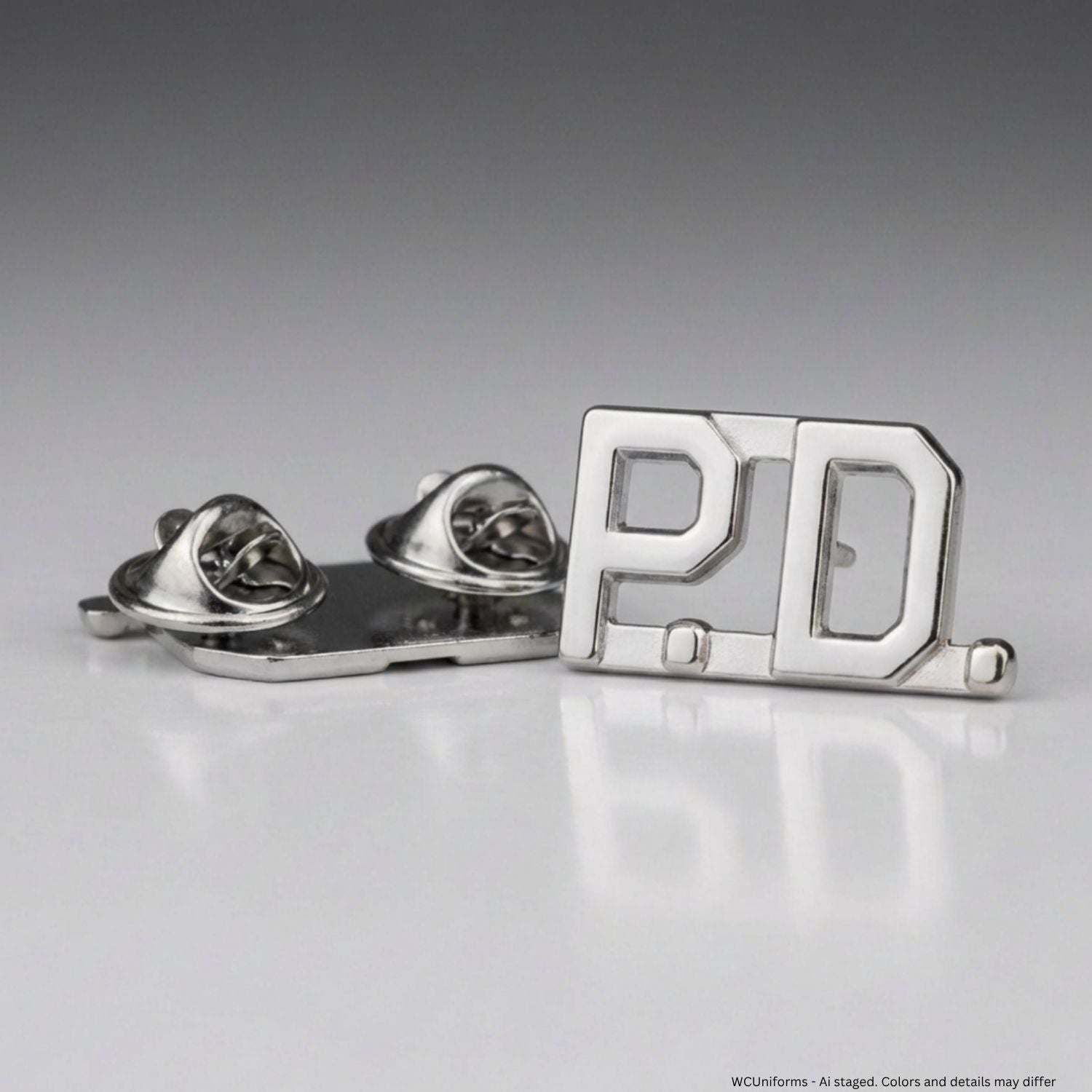 Metallic collar pins with 'P.D.' on a gray background