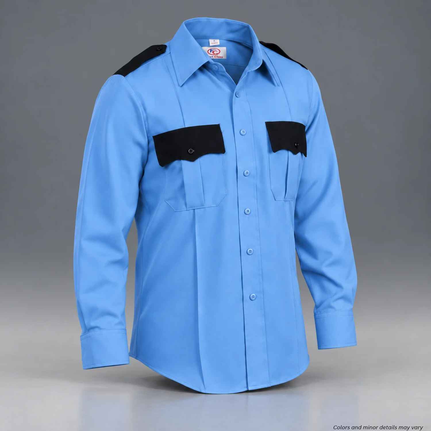 A light blue long-sleeve uniform shirt with black shoulder epaulets and black chest pocket flaps, displayed on a neutral gray background.
