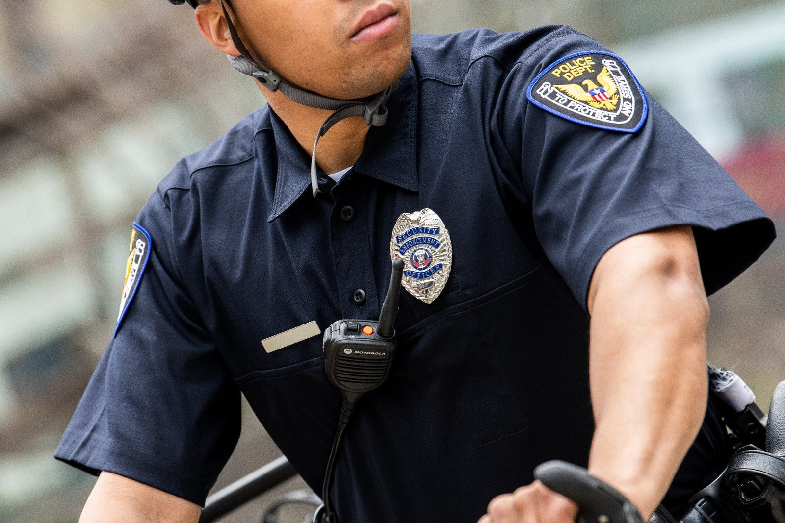 Law enforcement officer wearing Flying Cross FX STAT Hybrid Shirt with badge, radio, and department patch visible