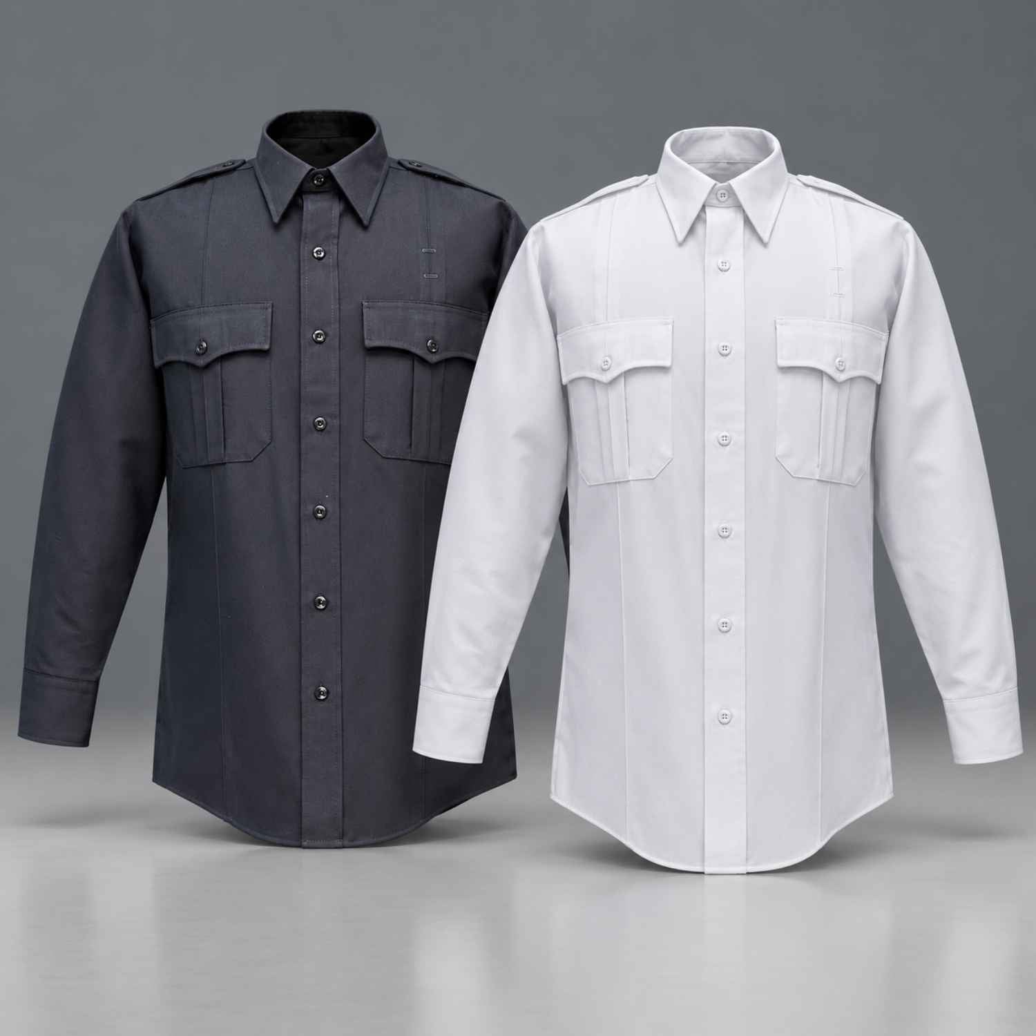 Two long-sleeve button-front shirts displayed side by side on a gray studio background. The left shirt is dark charcoal gray, and the right shirt is white.