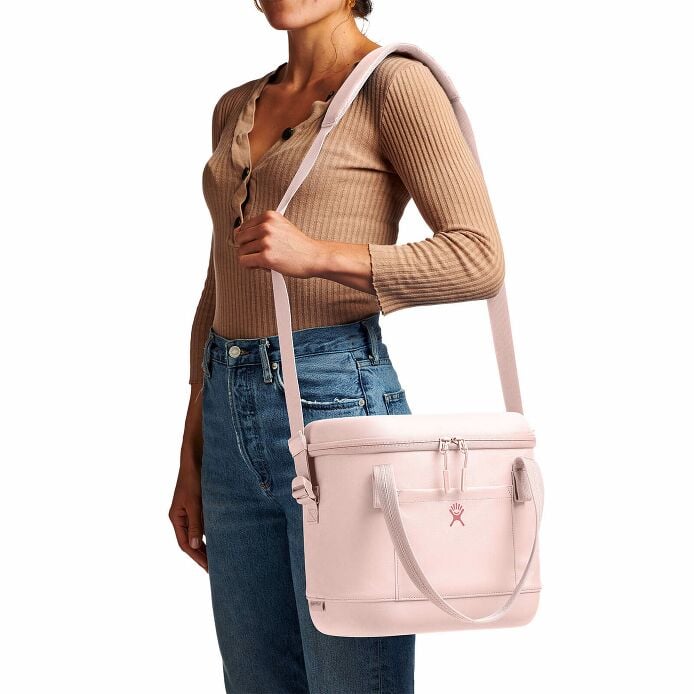 Woman wearing a Hydro Flask 12L Carry Out Soft Cooler in Trillium color, showcasing its stylish design and practical use.