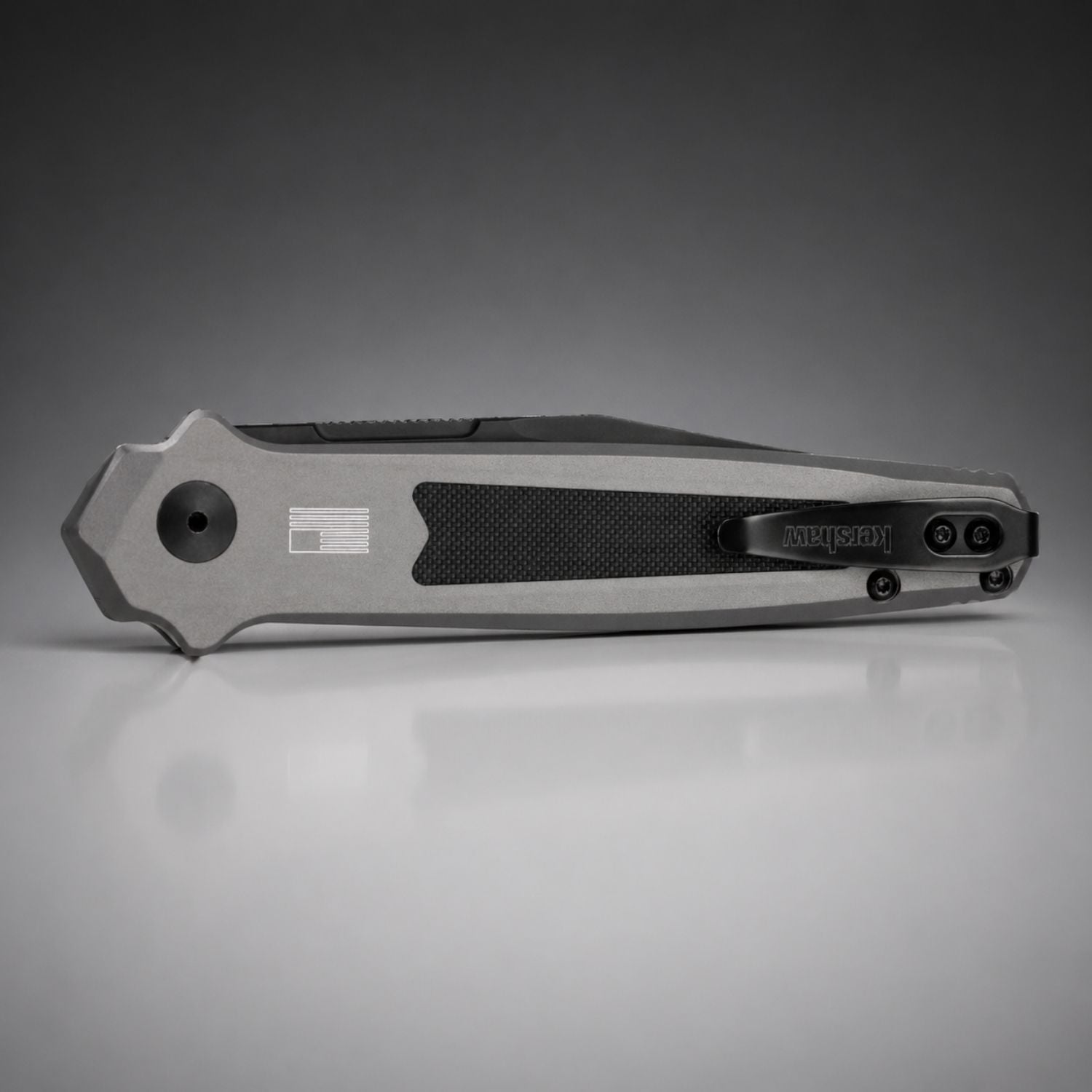 Folding knife with a metallic finish on a gray background