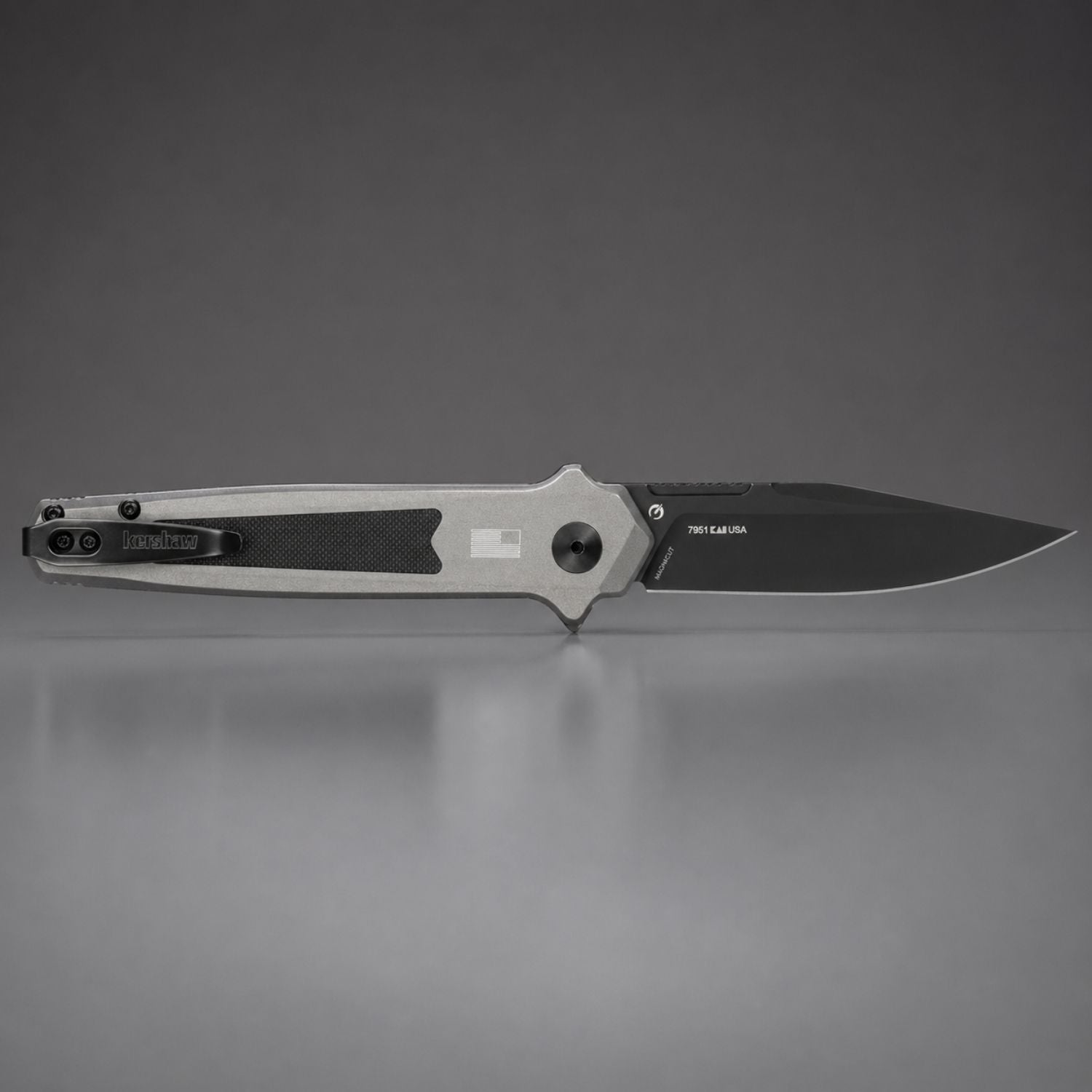 Folding knife with a metallic blade and black handle on a gray background