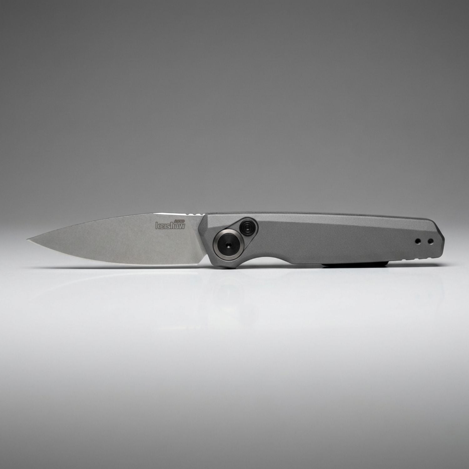 Folding knife with a metallic blade and handle on a gray background