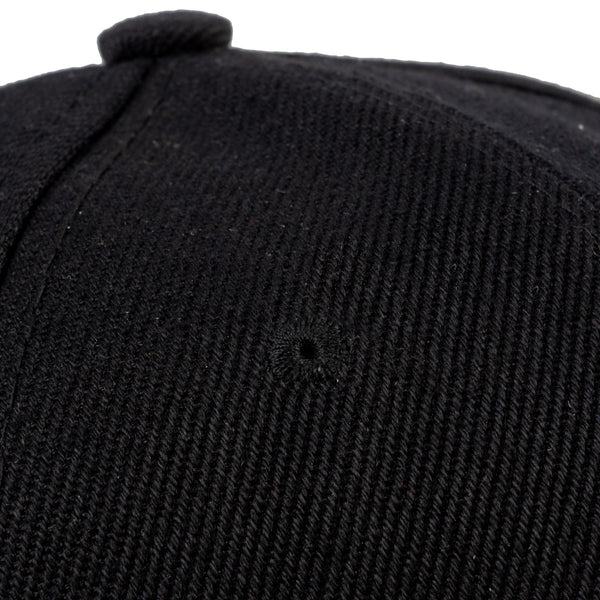 Close-up of a textured black cap on a white background