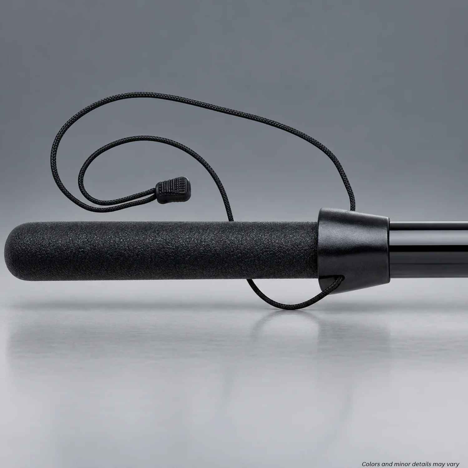 Monadnock LAPD/NYPD baton stop 2716 with black retention cord and zipper pull fitted on a straight baton, 1000187 on a gray background