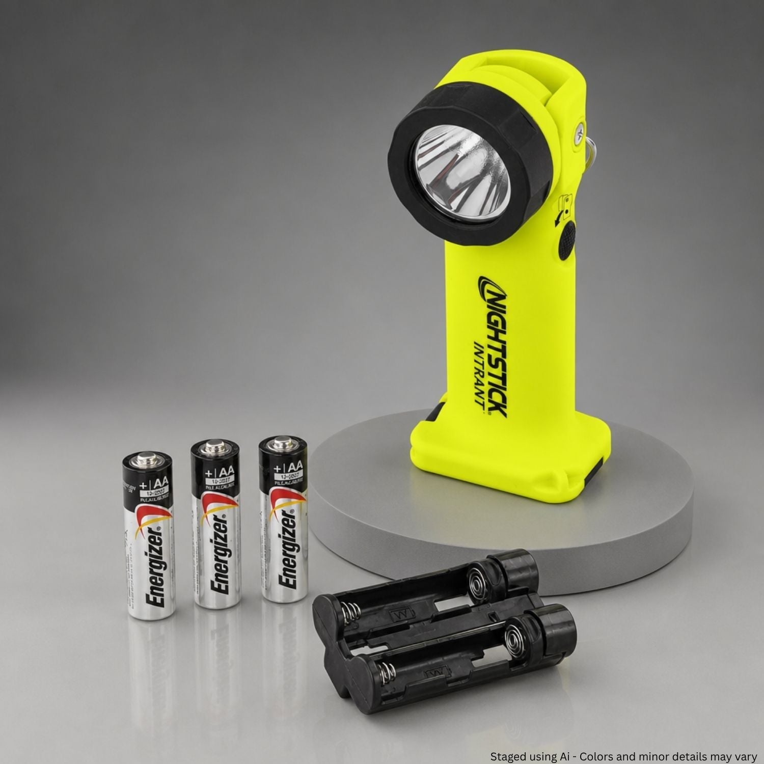 Yellow flashlight with batteries on a gray background