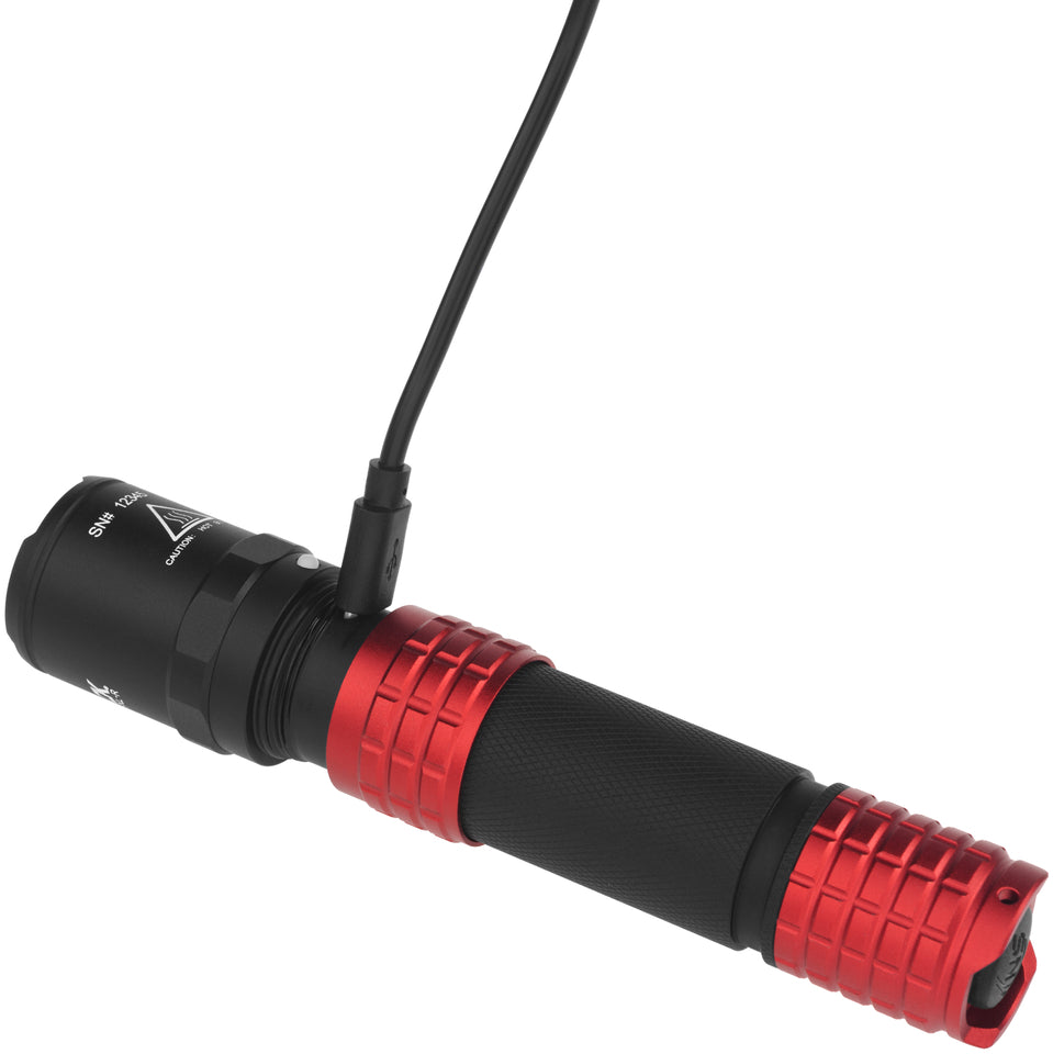 Nightstick USB-558XL-R tactical flashlight in red, shown charging via USB cable