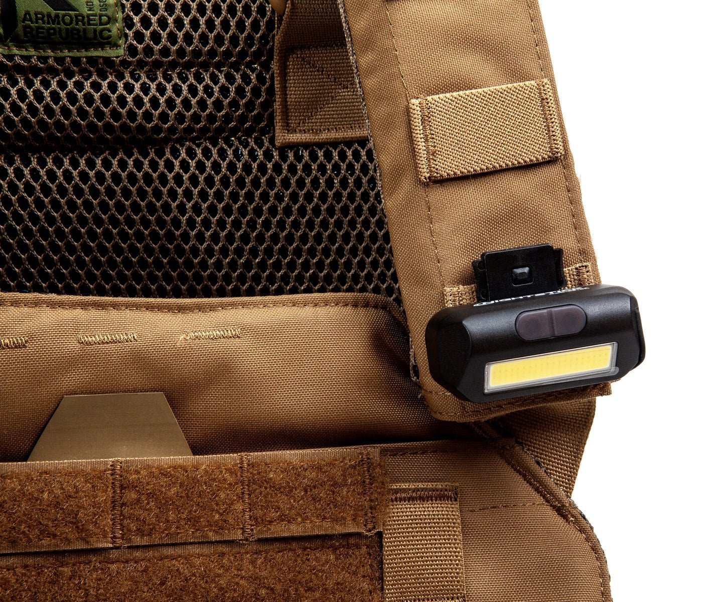 Tactical vest with a flashlight attachment on a white background