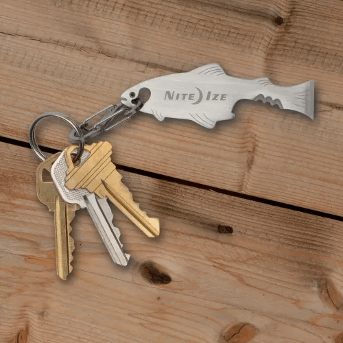 Nite Ize DoohicKey FishKey multi-tool on a key ring with other keys on a wooden surface.