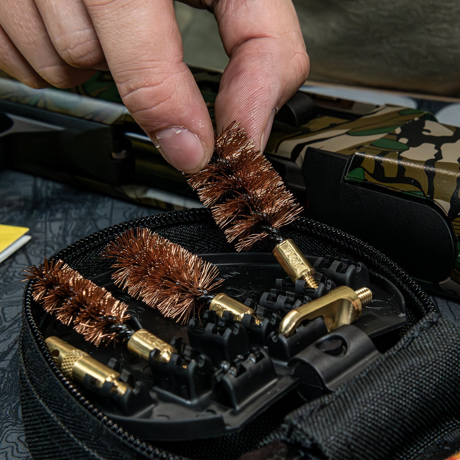 Selecting a marked bronze bore brush from the Otis FG-410 shotgun cleaning kit