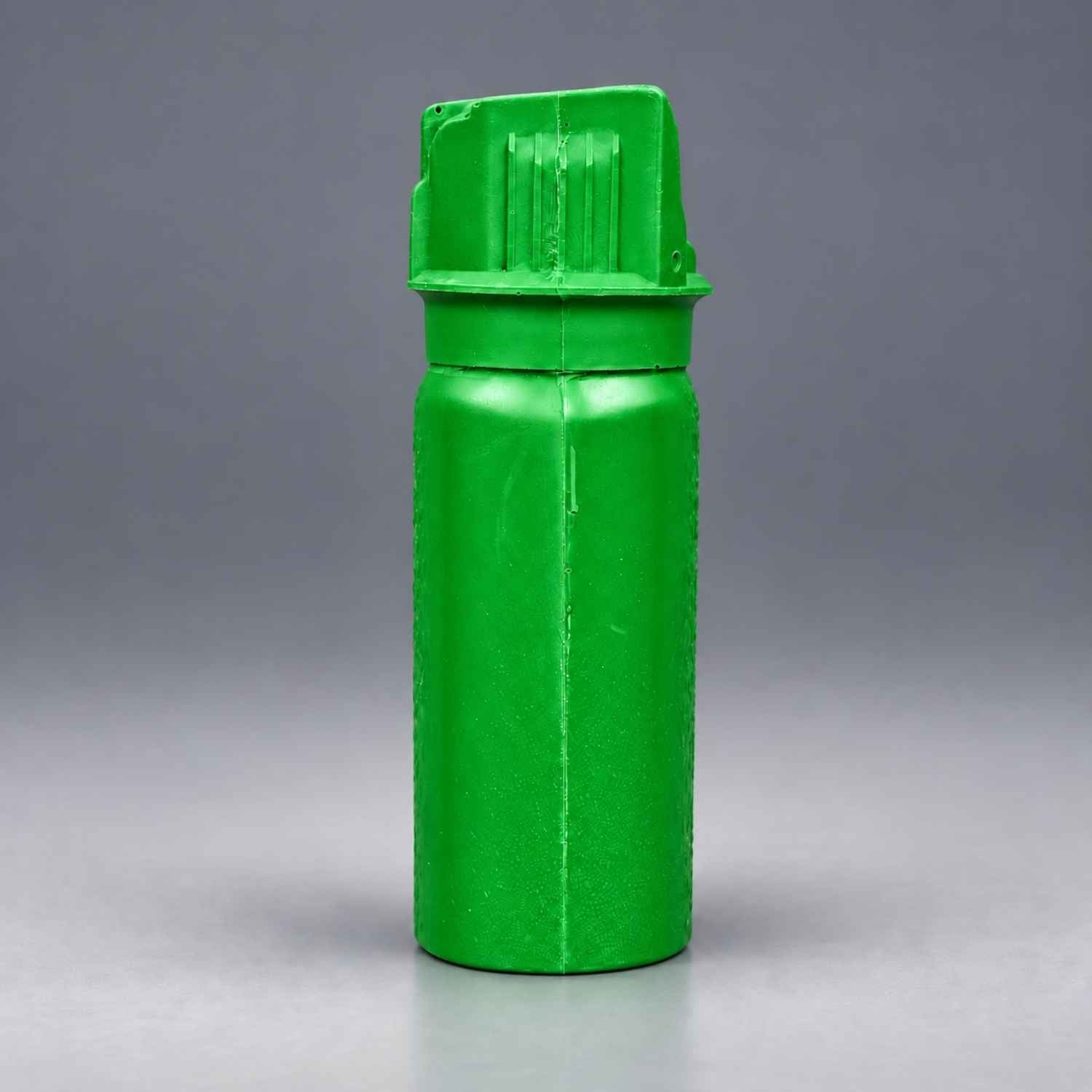 Rings Blueguns MK-3 green pepper spray training replica with molded details on a gray background