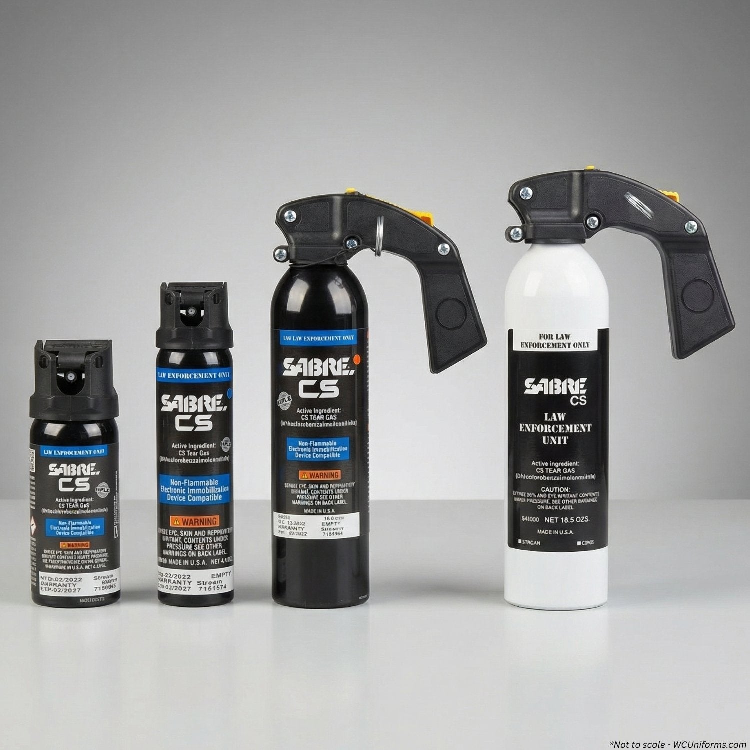 Collection of Sabre CS pepper spray canisters on a gray background