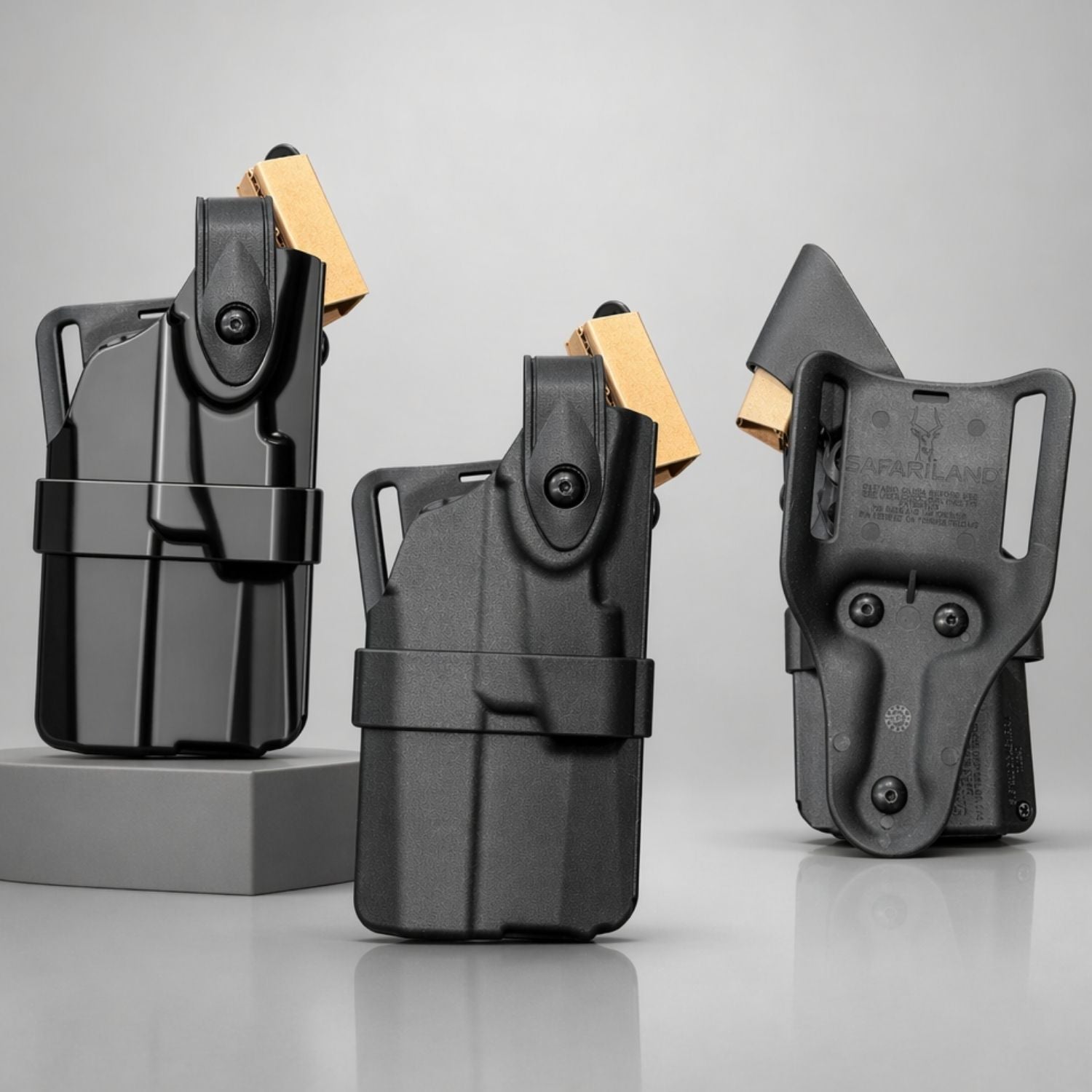 Three black gun holsters on a gray background