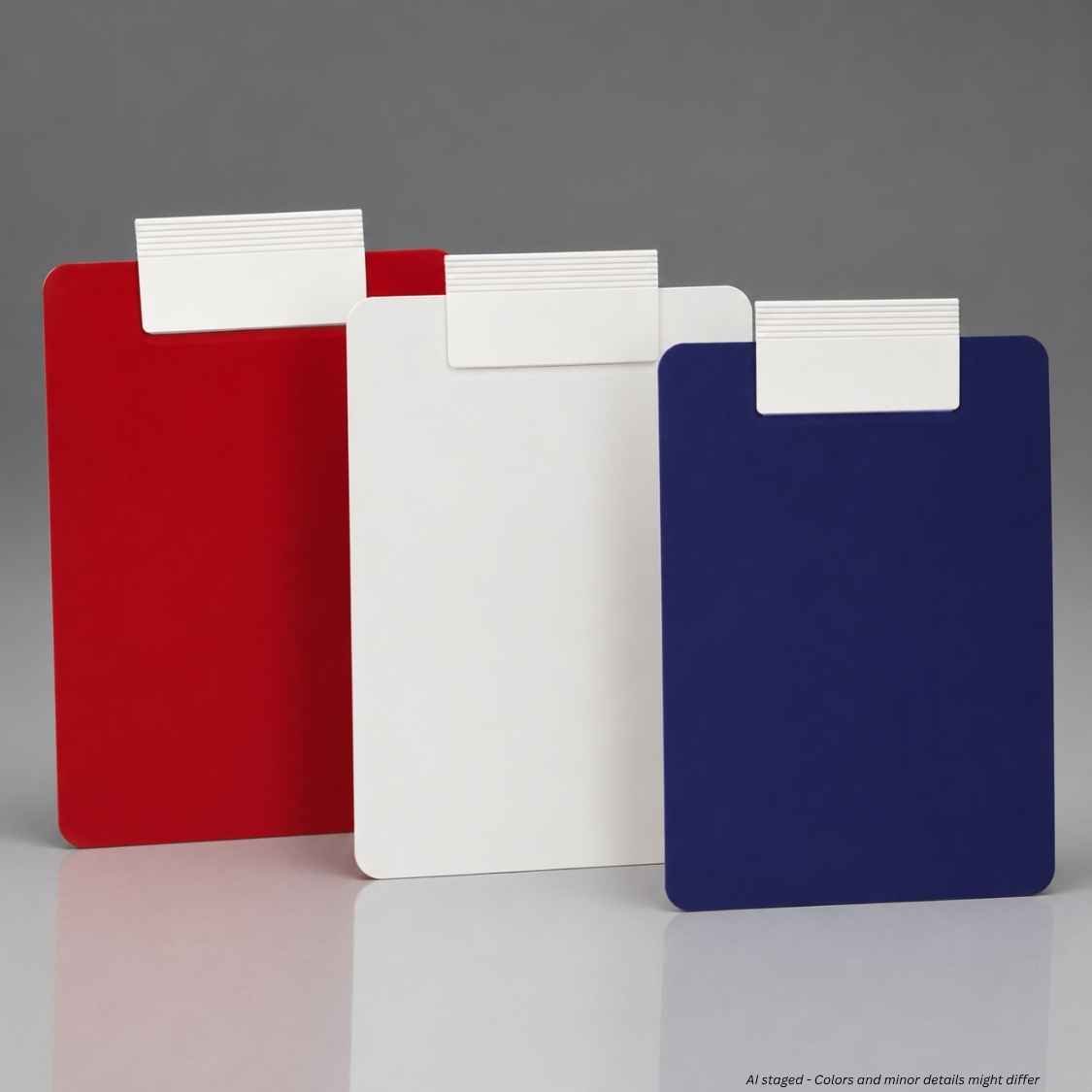 Three flat rectangular color clipboards standing upright on a reflective gray surface: red, white, and dark blue, each with a small white tab at the top.