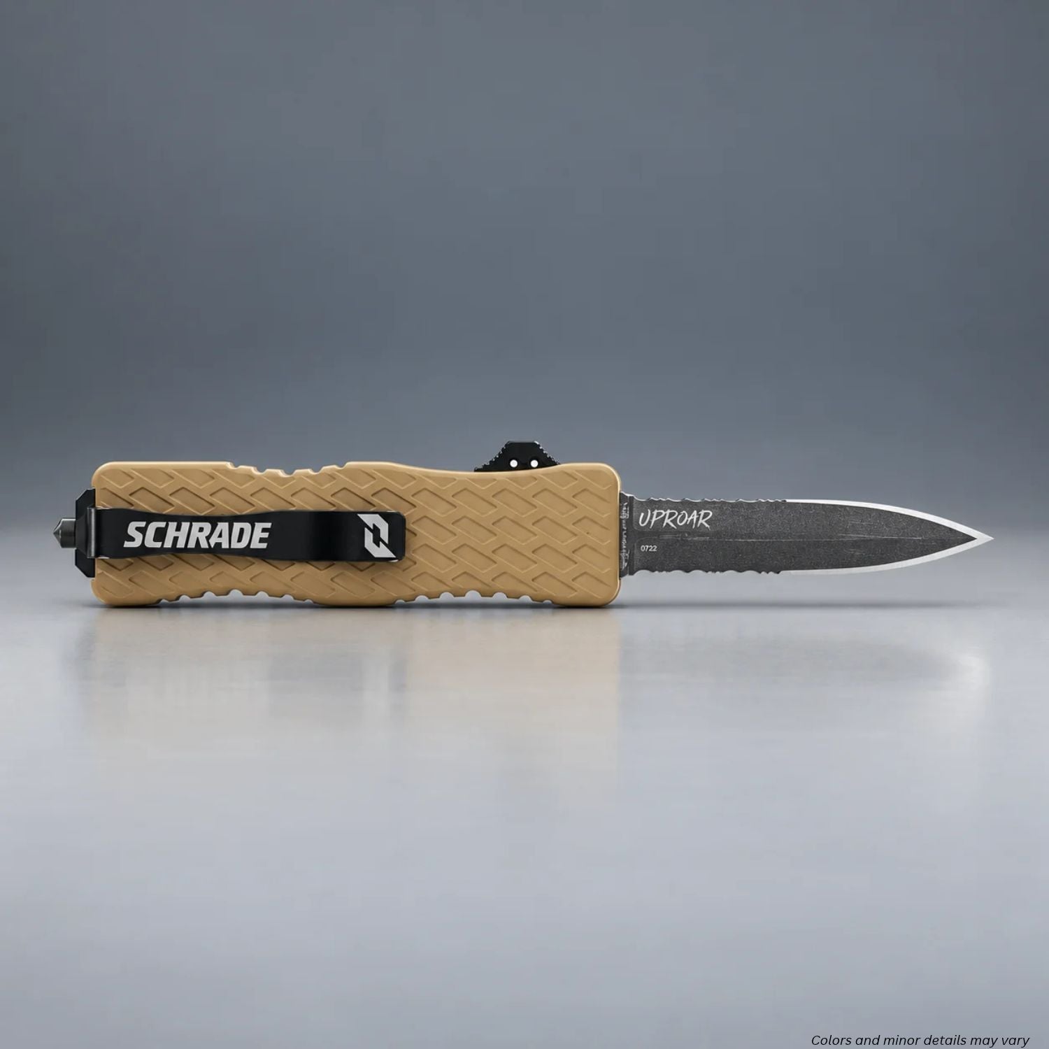 Schrade Uproar Tactical FDE OTF knife with blade deployed and Schrade pocket clip, resting on a gray surface