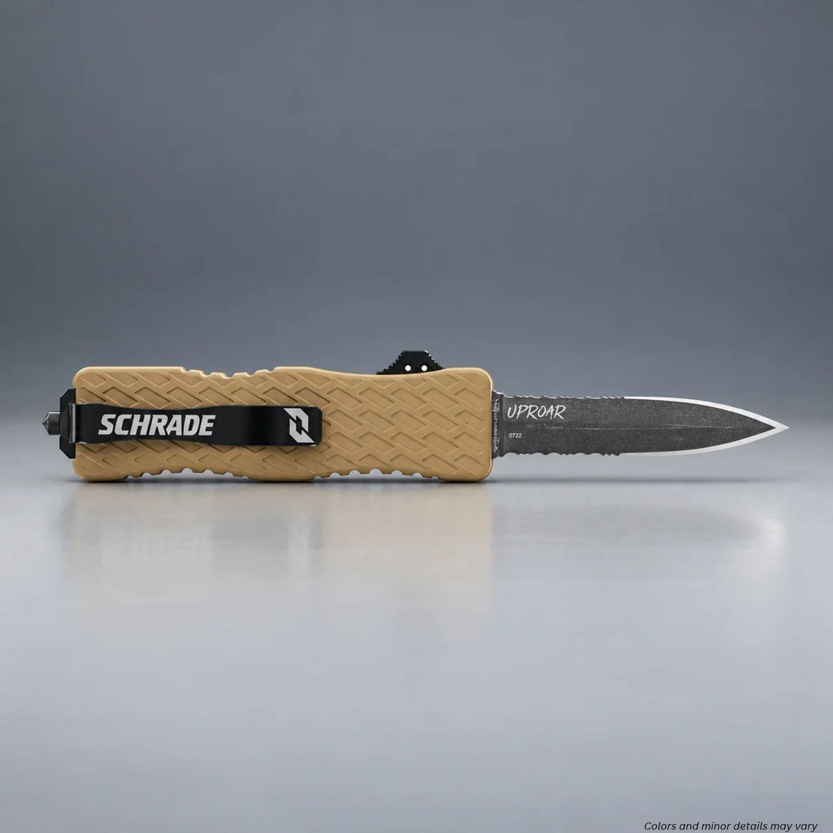 Schrade Uproar Tactical FDE OTF knife with blade deployed and Schrade pocket clip, resting on a gray surface