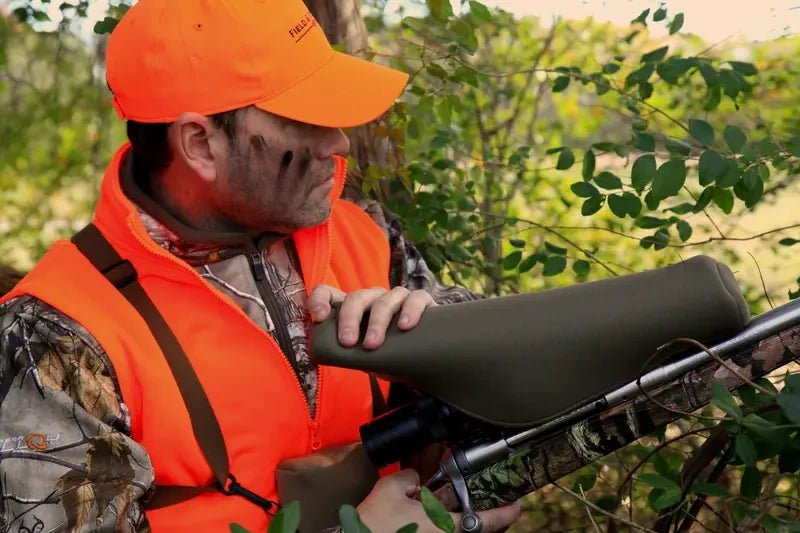 Hunter in the field with a SENTRY Scopecoat protecting the rifle scope
