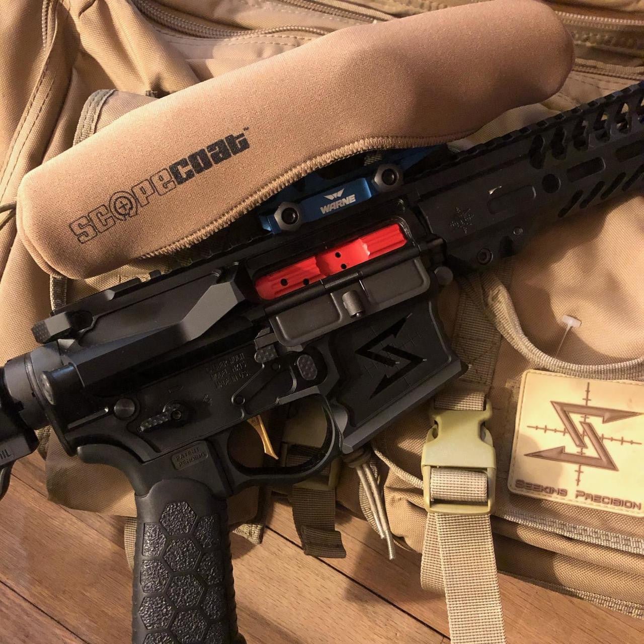 Black rifle with red accents on a tactical backpack