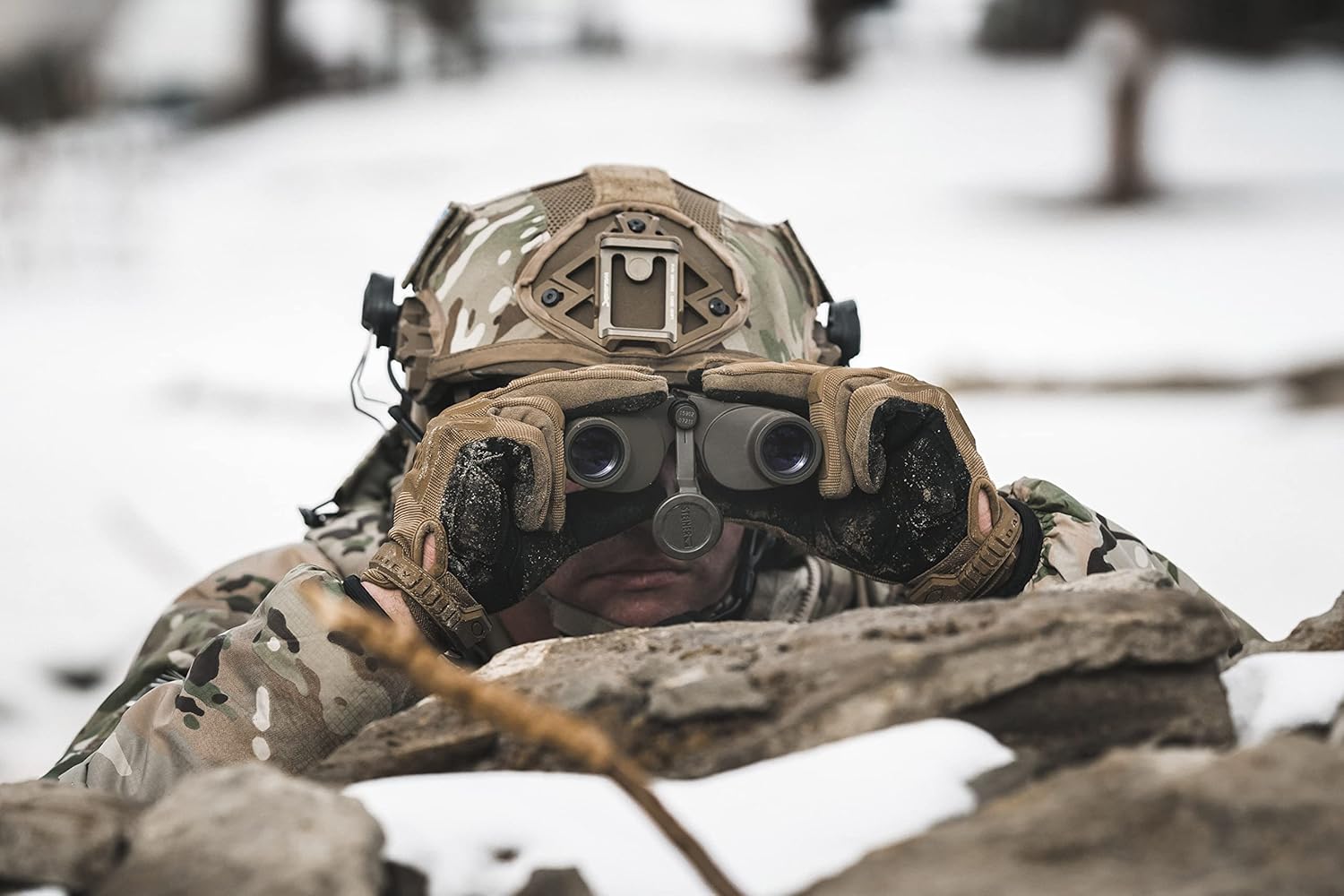 Soldier using binoculars in the snow