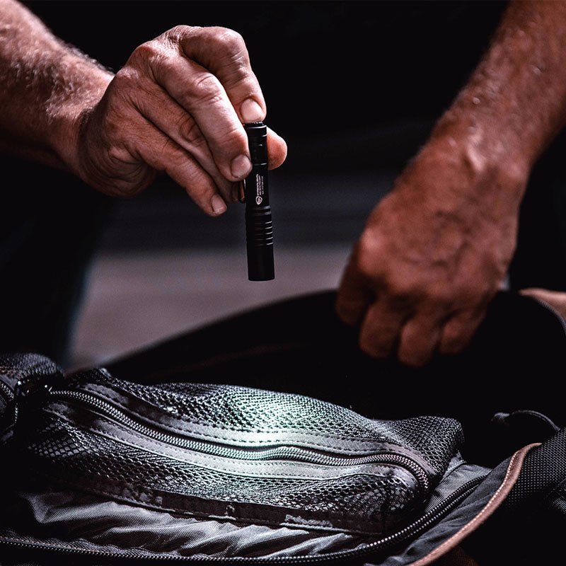 Black Streamlight MicroStream USB flashlight being placed in an open tool bag