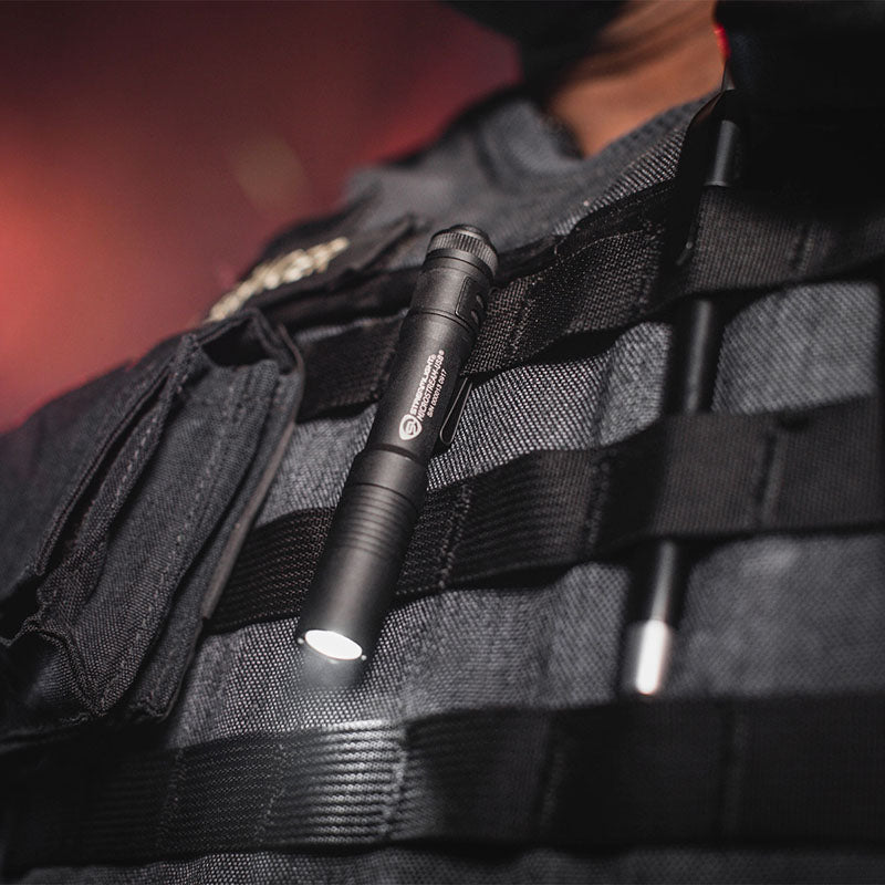 Black Streamlight MicroStream USB pocket light clipped to a tactical vest with the light on